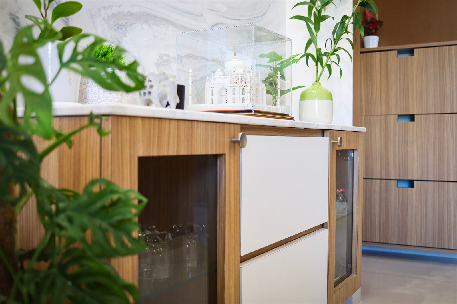 a white cabinet with a white and green plant in it