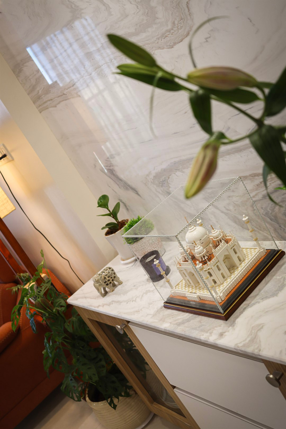 a white model of a castle in a glass case on a marble counter