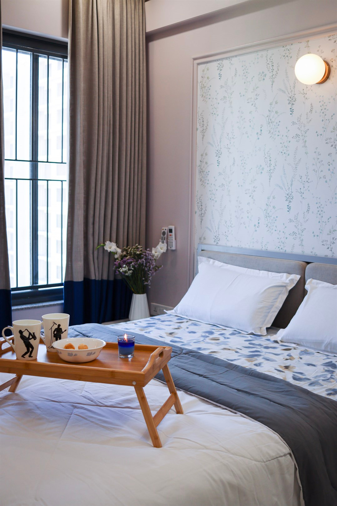 a bed with a tray of food and candles in front of it