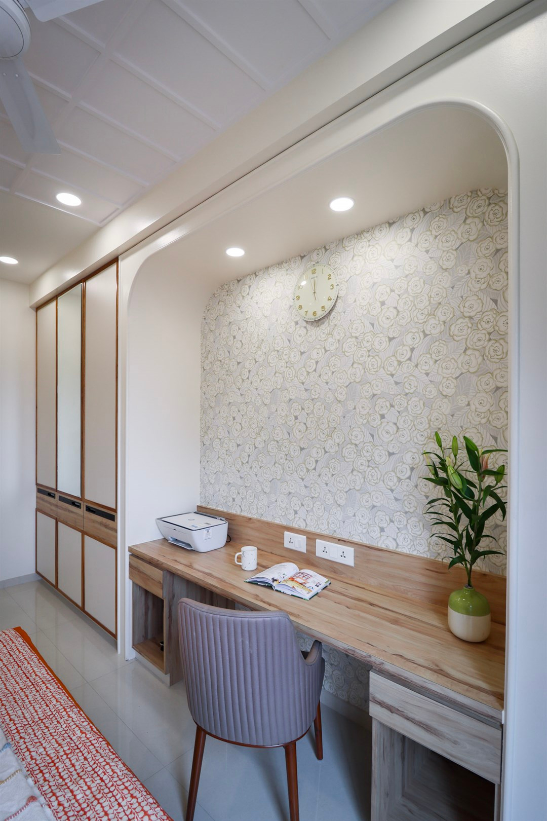 a desk with a chair and a clock on the wall