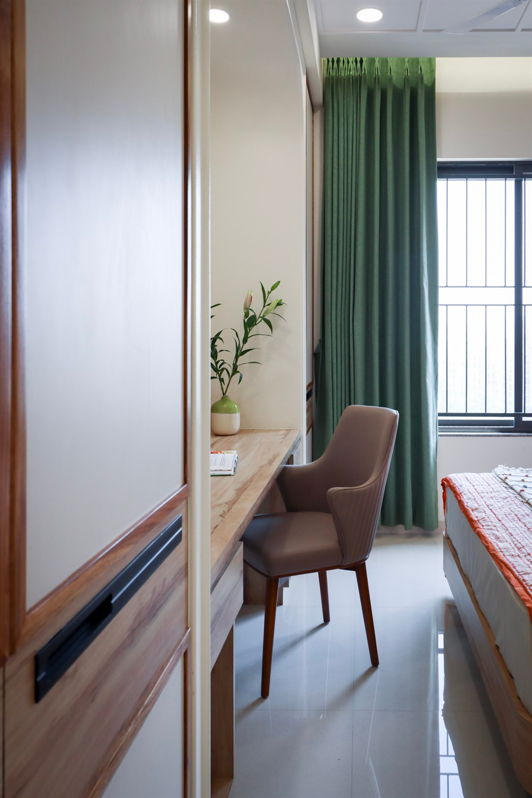 a desk with a chair and a plant in a room